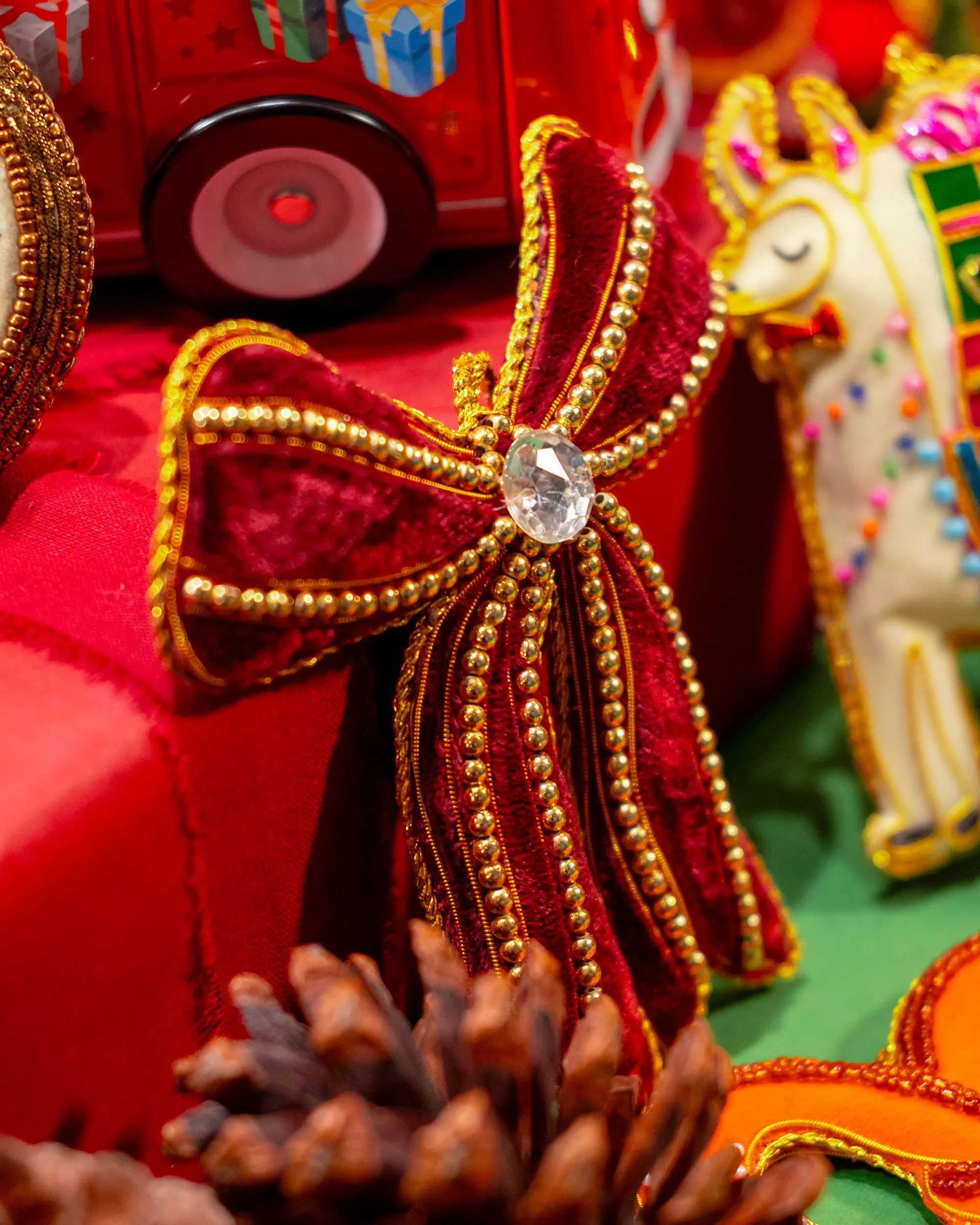 VARSHA JARIWALA Maroon Bow With Golden Beads Ornament